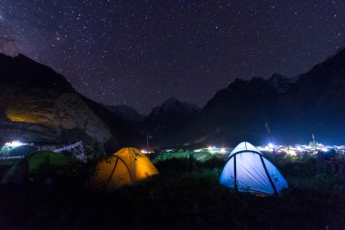 arka planda parıldayan yıldız ile Samanyolu altında kamp çadırı