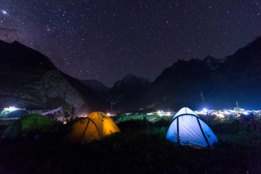 arka planda parıldayan yıldız ile Samanyolu altında kamp