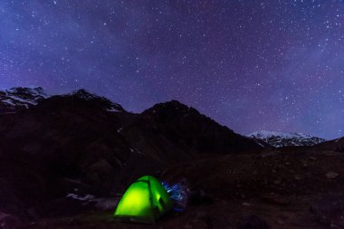 arka planda parıldayan yıldız ile Samanyolu altında kamp