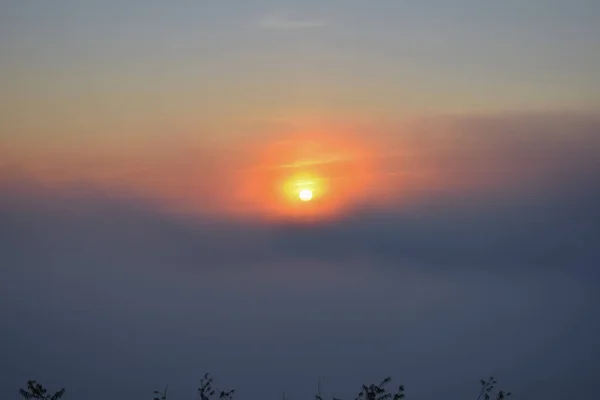 夜明けの密な霧と青い空を背景に日の出 — ストック写真