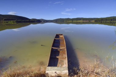 Lakeside taze doğa ve mavi gökyüzü arka plan ile küçük eski balıkçı teknesi