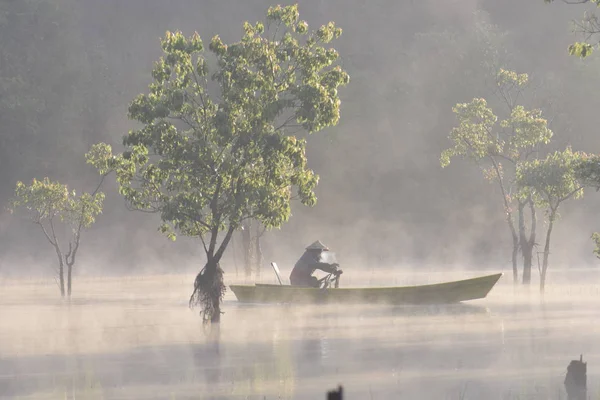 淹没的树木和渔船上的湖泊与浓雾和神奇的光在日出 — 图库照片