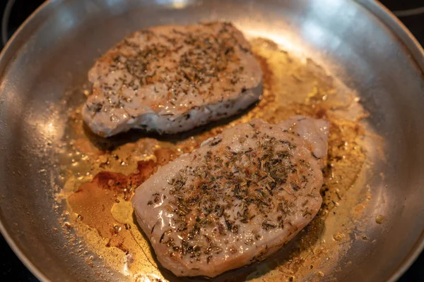 İki porsiyon biftek otlar ve baharatlar görünümü yukarıdaki kadar yakın bir tavada pişirme ile terbiyeli