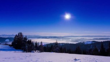 Sis, yıldız şeklinde bir gökyüzüyle kışın dağı aşıyor.