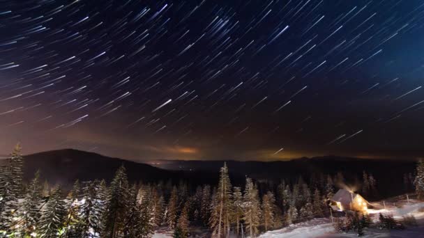 Estrellas moviéndose por encima de la pequeña casa en las montañas en WInter. Ucrania, Cárpatos — Vídeos de Stock