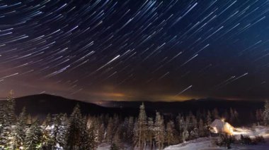 Kışın dağlarda küçük evin üzerinde hareket eden yıldızlar. Ukrayna, Karpat