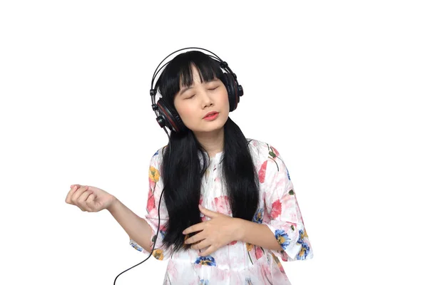 ヘッドフォンにもかかわらず音楽を聴くかわいいアジアの女の子. — ストック写真