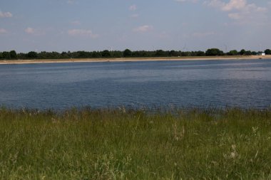 çim, su, plaj ve deniz kenarındaki ahşap geeste Almanya mavi gökyüzü ve beyaz bulutlar ile geniş açı mercek ile fotoğrafı