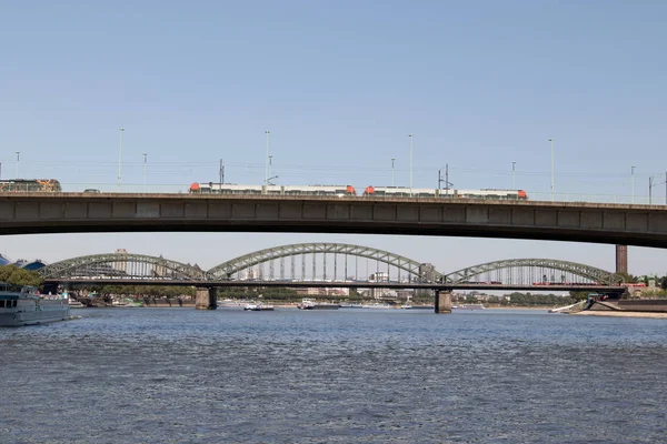 川のボート旅行の間に撮影したドイツ ケルンのバック グラウンドで Severins Deutzer 橋を通過する列車ラインの広角のレンズします — ストック写真