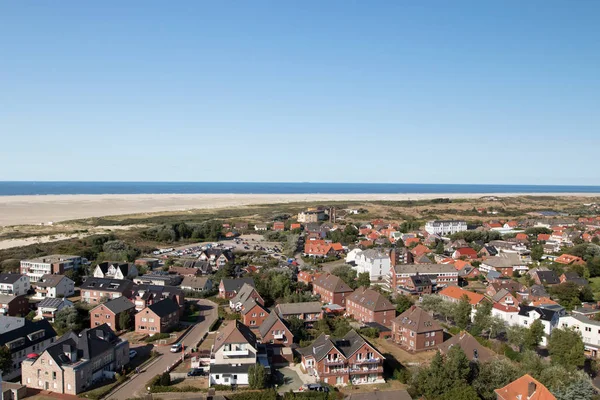 a look from above the lighthouse of the northern sea island borkum on the buildings and the beach and the sea at the horizon photographed during a sightseeing tour on the northern sea island borkum in germany with wide angle lens