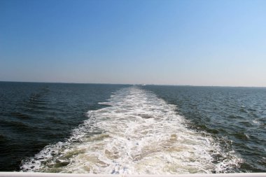 kuzey deniz adasında mavi bir gökyüzü altında bir gemi tarafından hareket eden su görünümü juist Almanya güneşli bir günde bir gezi turunda fotoğraflandı