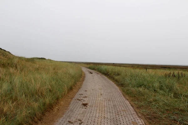 晴れた日の観光ツアーで撮影された北海の島のジューストドイツの砂丘の間の歩道を見る — ストック写真