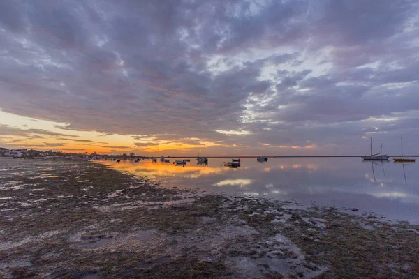 Nascer do sol paisagem marinha nublada, no parque natural da Ria Formosa zonas húmidas, filmado na praia de Cavacos. Algarve. Portugal . — Fotografia de Stock