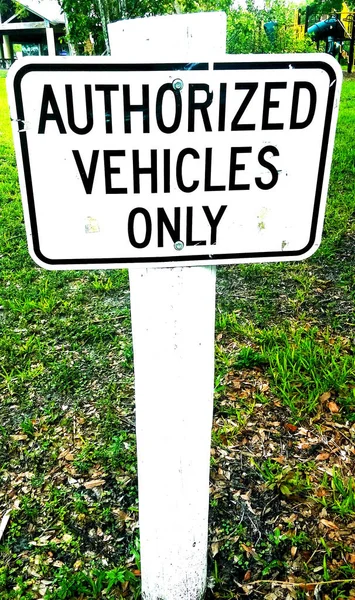 白色交通标志授权车辆只在木柱上签名 — 图库照片