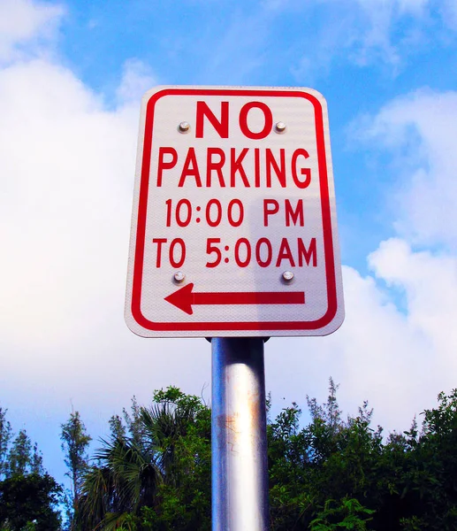 在10Pm 和下午5点之间没有停车在金属杆上的红色箭头金属标志 — 图库照片