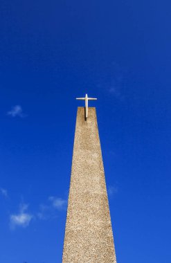 Kahverengi ve kahverengi peables bir haç üstünde ve mavi bir gökyüzü ve bulutlar beyaz arka plan ile topluluk Episcopal kilise çan kulesi yapılmış.