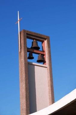 Kahverengi ve tan peables altın bir haç üstünde ve mavi bir gökyüzü ve bulutlar beyaz arka plan ile topluluk Episcopal kilise çan kulesi yapılmış.