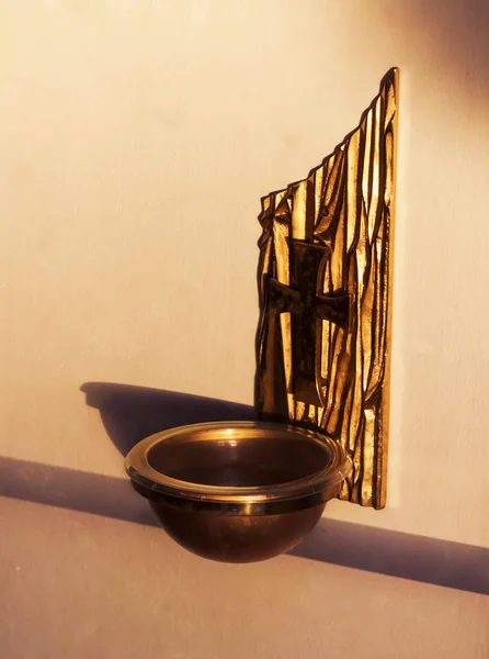 Entry way Bronce Holy Water Holder in a Catholic Church. Holy water bowl attached to the wall at the entry way of a Catholic Church