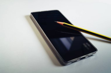 Beyaz arka plan üzerinde basit siyah ve sarı kalem ile akıllı telefon. Yan vurdu. Teknoloji, sosyal medya, programlama, matematik, bussines office kavramı. 