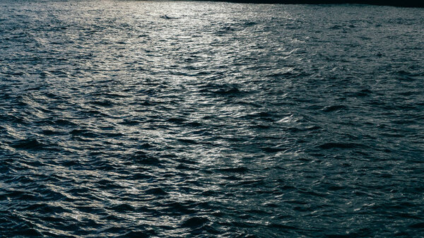 Dark, calmly waving sea lake river blue water. Nature texture background concept.