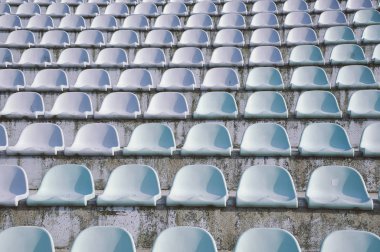 Minimalist basit bir kadeh mavi eski kirli stadyum koltukları üst üste kırık. Terk edilmiş Stadyumu.