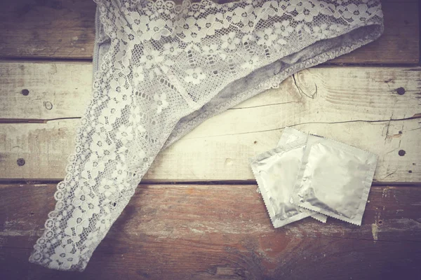 Tanga ve prezervatif ahşap masa üzerinde