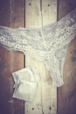 Tanga ve prezervatif ahşap masa üzerinde