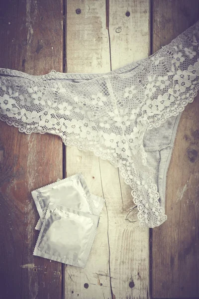 Tanga ve prezervatif ahşap masa üzerinde