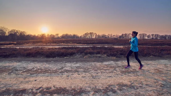 Runner girl, winter landscape at sunshine