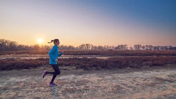 Runner girl, winter landscape at sunshine