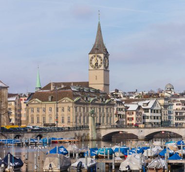 Zürih şehir kış, Aziz Peter Kilisesi üstlerindeki Munsterbrucke Köprüsü Kulesi Limmat Nehri boyunca tarihi bölümü'nün binalar. Zürih İsviçre, onun iyi korunmuş ortaçağ tarihi kent için bilinen en büyük şehridir.