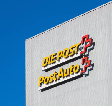 İsviçre yazısı ve Postauto işaretleri bina otobüsün üzerinde 