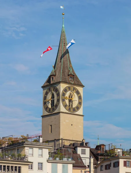 Torre della chiesa di San Pietro nella città di Zurigo, decorata con bandiere della Svizzera e Zurigo — Foto Stock