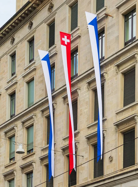 Fasada budynku w zabytkowej części miasta Zurych ozdobione flagami Zurychu i Szwajcarii — Zdjęcie stockowe