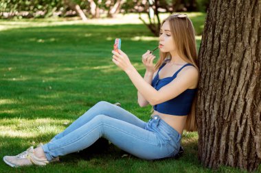 Kızın dudaklarını boyalar 