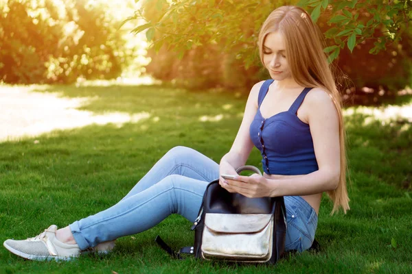 Dziewczyna Siedzi Trawniku Patrząc Telefon — Zdjęcie stockowe