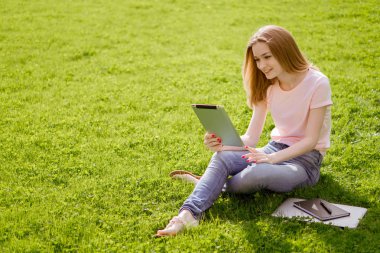 Bir tablet ile parkta kız