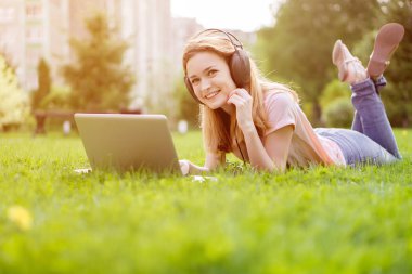 Kız Par kulaklık müzik bir laptop