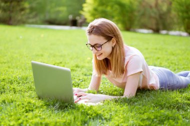 bir dizüstü bilgisayarda yazarak'ın bahçesinde kız