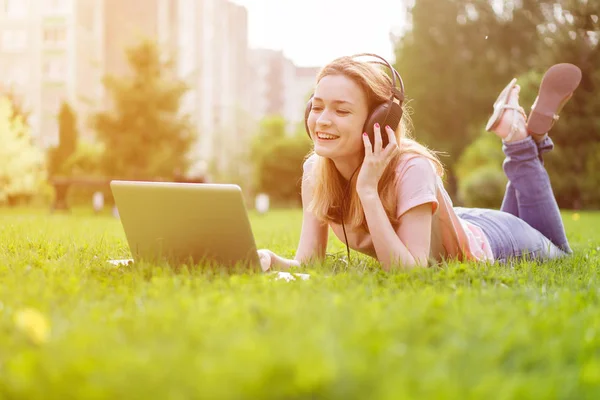 Kız Par kulaklık müzik bir laptop