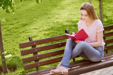  Kız parkta bir bankta oturmuş bir defter ile