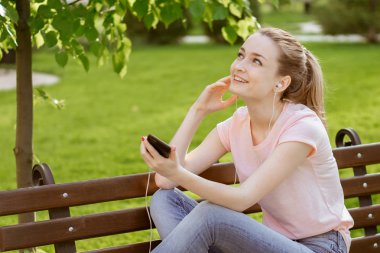 Kız parkta bir bankta müzik dinlemek