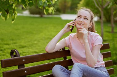 parkta bir bankta telefonda konuşan kız