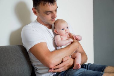 baba bebek tutan ve kameraya doğru görünüyor