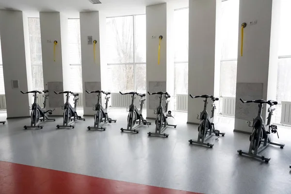 Modern bir spor salonu iç ekipmanları ile. Satır egzersiz bisikletleri detay eğitimi, backlight. Sağlıklı yaşam konsepti
