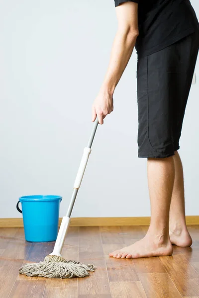 the man washes the floor in the apartment