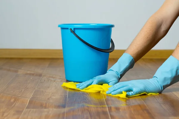 the man washes the floor with a rag in the apartment