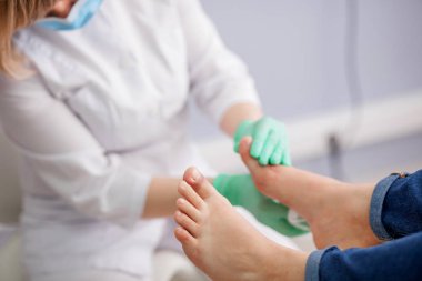 Doktor, ayak hastalıkları uzmanı ayak inceliyor.