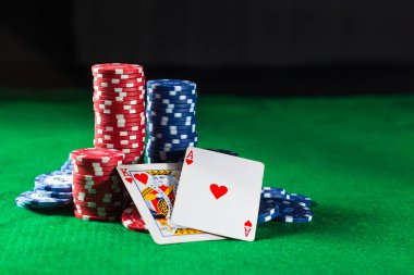 Yeşil bir arka plan üzerinde iki kart kral ve Ace Poker fişleri.