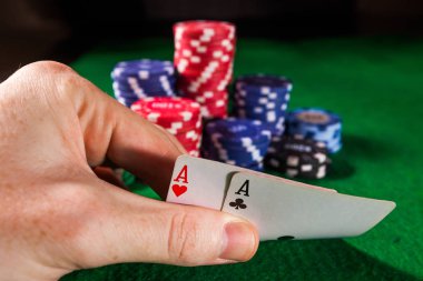 Yeşil zemin üzerine iki as ile Poker fişleri.